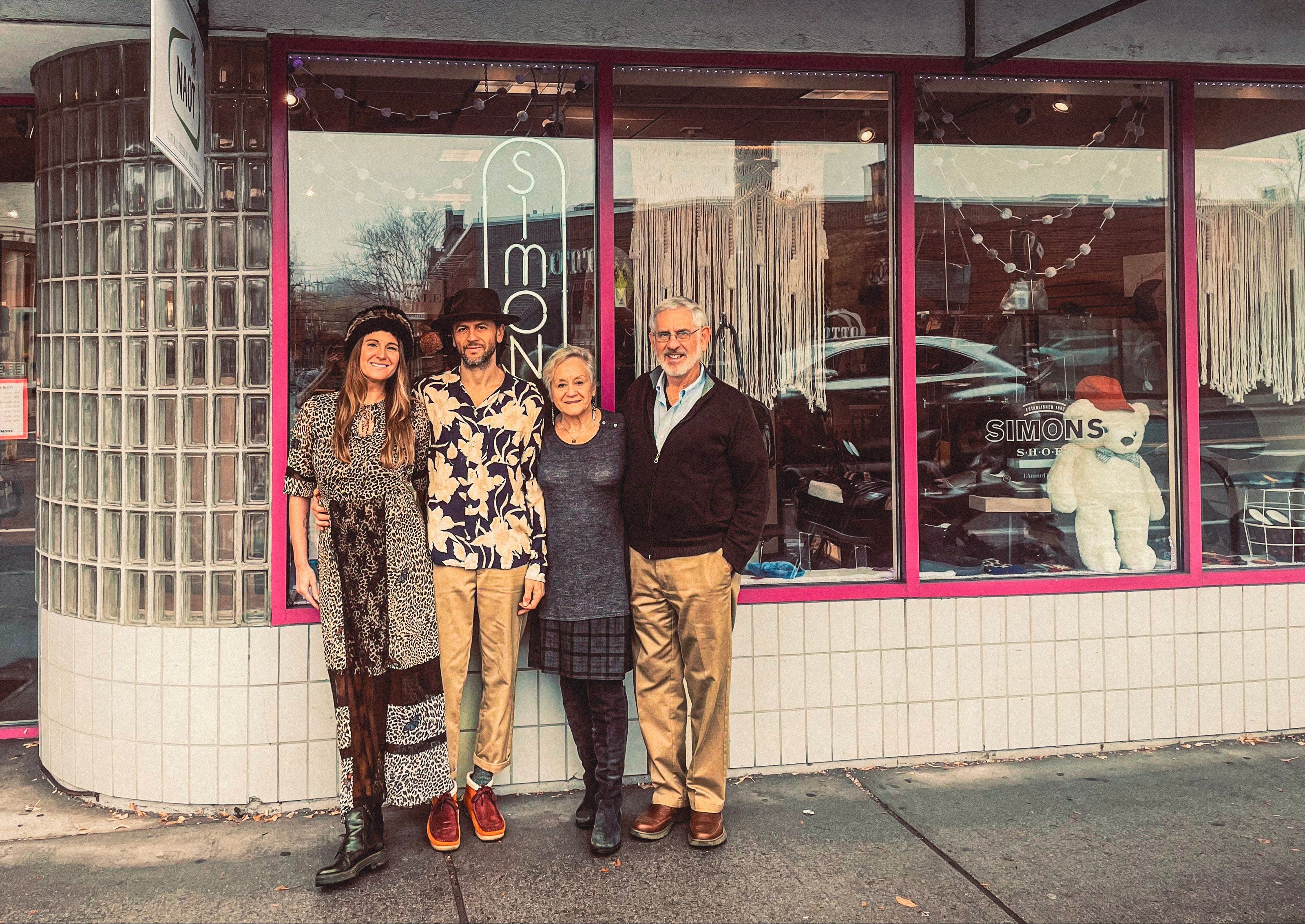 Four people standing in front of a Simons Shoes store