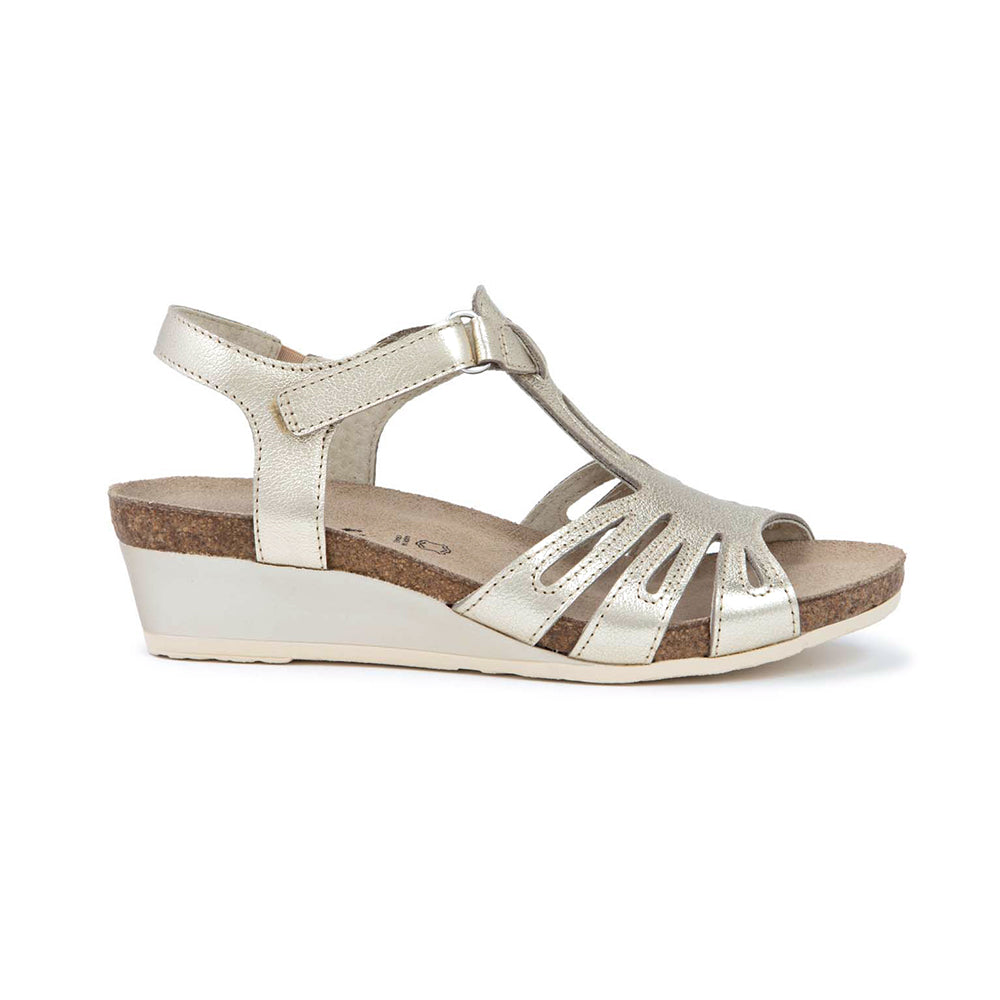 Dansko Starlet Leather Wedge Sandal, T-strap from the toe to adjustable ankle strap that wraps around the ankle, gold shine leather  with glitter texture. Footbed is light brown cork and sole is light beige. | Side view | Simons Shoes 