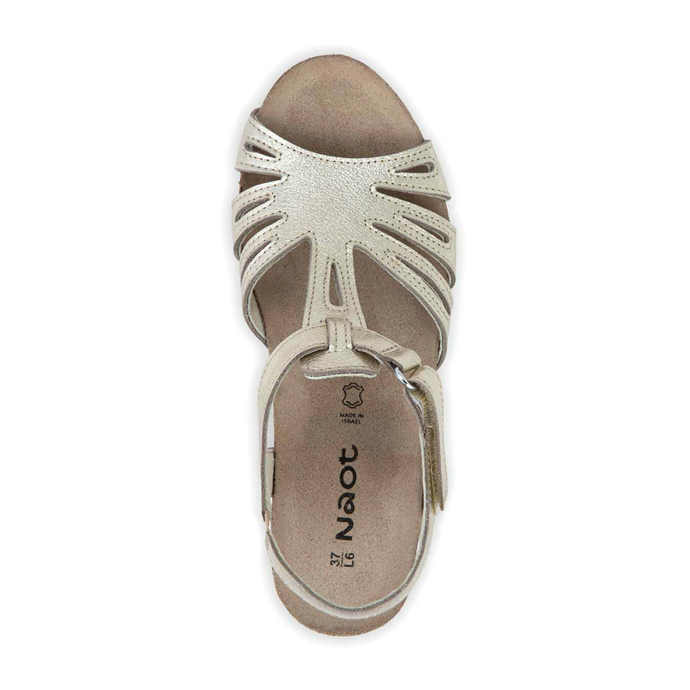 Dansko Starlet Leather Wedge Sandal, T-strap from the toe to adjustable ankle strap that wraps around the ankle, gold shine leather  with glitter texture. Footbed is light brown cork and sole is light beige. | Above view | Simons Shoes 