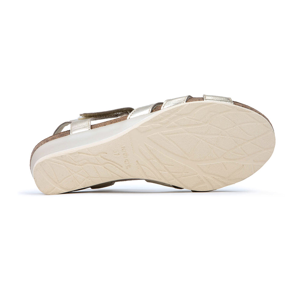 Dansko Starlet Leather Wedge Sandal, T-strap from the toe to adjustable ankle strap that wraps around the ankle, gold shine leather  with glitter texture. Footbed is light brown cork and sole is light beige. | Below view | Simons Shoes 
