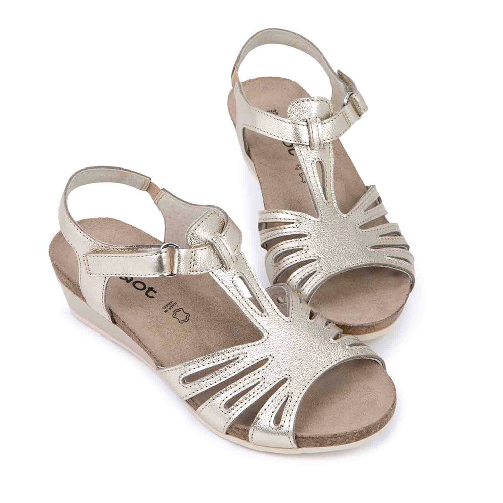 Dansko Starlet Leather Wedge Sandal, T-strap from the toe to adjustable ankle strap that wraps around the ankle, gold shine leather  with glitter texture. Footbed is light brown cork and sole is light beige. | Side view | Simons Shoes 